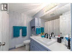The four-piece bathroom features a full tub and shower, updated vanity and useful storage. - 
