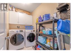 A large in-suite laundry room provides side-by-side machines and valuable household storage. - 