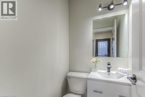 White vanity with integrated sink, black single-handle faucet, wall-mounted mirror, and track lighting fixture - 152 Overlea Drive, Kitchener, ON 