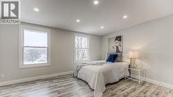 Recessed lighting, light gray wall color, wood-finish flooring, two double-hung windows - 