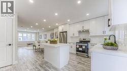 Open-concept living space with wood-finish flooring, recessed lighting, and a kitchen island - 