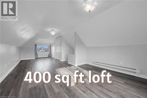 Spacious loft featuring wood-finish flooring, white walls, multiple built-in closets, and two ceiling-mounted light fixtures - 9 Melrose Avenue S Unit# Upper, Hamilton, ON 
