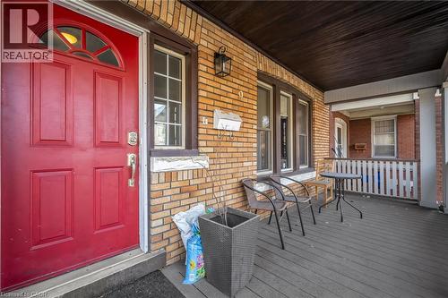 Brick exterior with a red paneled entry door featuring a transom window - 9 Melrose Avenue S Unit# Upper, Hamilton, ON 