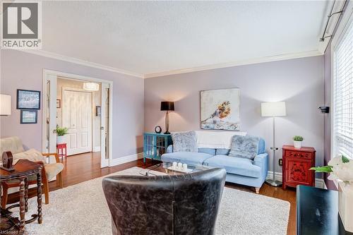 Hardwood-finish flooring throughout, crown molding, and a wide cased opening with pocket doors - 106 Appleford Road, Hamilton, ON 