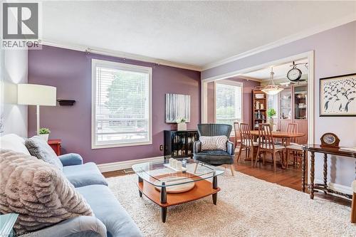 Hardwood flooring in dining area, crown molding, white trim, recessed archway, and built-in shelving - 106 Appleford Road, Hamilton, ON 
