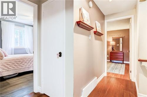Hallway with wood-finish flooring and neutral wall tones - 106 Appleford Road, Hamilton, ON 