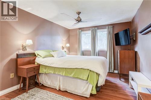 Recessed windows with drapes, wood-finish flooring, ceiling fan, and wall-mounted light fixtures - 106 Appleford Road, Hamilton, ON 