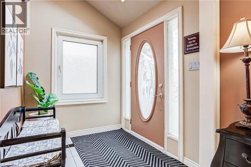 Entryway featuring a decorative front door with an oval glass insert, a side light, and an adjacent frosted window - 106 Appleford Road, Hamilton, ON 