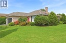 Brick exterior with a peaked roof, attached garage, and a prominent brick chimney - 9 Country Club Road, Cayuga, ON 