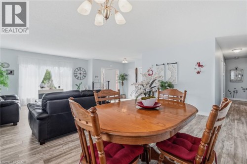 Wood-finish flooring throughout, with a dining area featuring a chandelier - 9 Country Club Road, Cayuga, ON 