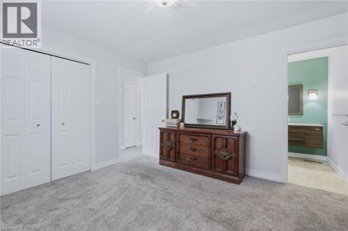 Carpeted flooring, white bi-fold closet doors, and light wall paint - 9 Country Club Road, Cayuga, ON 