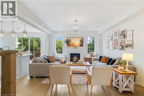 Open-concept living space featuring wood-finish flooring, a fireplace with a mantel, and recessed lighting - 68 Barkerville Drive, Whitby, ON 