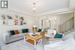 Recessed lighting throughout, contemporary chandelier, wood-finish flooring, staircase with painted balusters, and crown molding - 