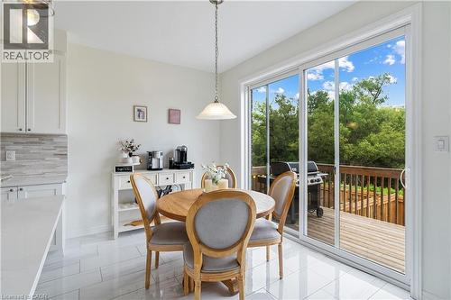 White shaker-style cabinetry, light-toned countertop, mosaic tile backsplash, and light-toned tile flooring - 68 Barkerville Drive, Whitby, ON 