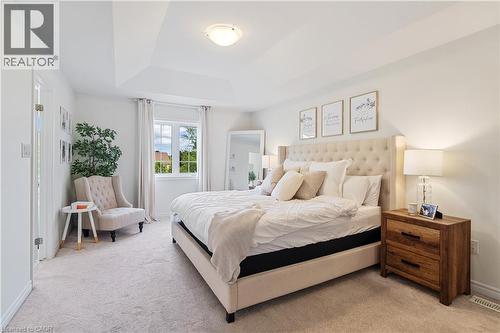 Tray ceiling with a flush mount light fixture, window with drapes, and neutral wall-to-wall carpeting - 68 Barkerville Drive, Whitby, ON 