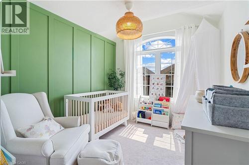 Board and batten accent wall, arched window with white trim, white window sheers, woven pendant light, and light-toned carpeting - 68 Barkerville Drive, Whitby, ON 