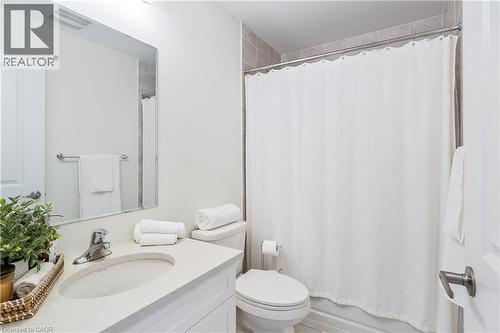 Vanity with integrated sink, rectangular mirror, chrome faucet, and tiled shower surround - 68 Barkerville Drive, Whitby, ON 
