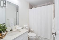 Vanity with integrated sink, rectangular mirror, chrome faucet, and tiled shower surround - 