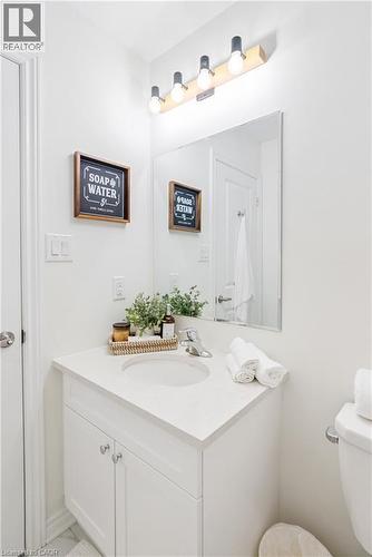 White vanity with an integrated sink, polished chrome faucet, and a rectangular mirror - 68 Barkerville Drive, Whitby, ON 