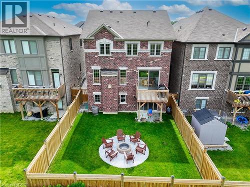 Brick exterior with white window trim, upper-level wood deck, and a fenced backyard - 68 Barkerville Drive, Whitby, ON 