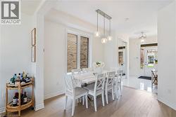 Recessed lighting, wood-finish flooring, white trim, and a three-light linear pendant fixture - 
