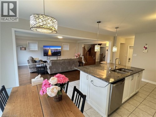 Kitchen island with granite countertop, double basin sink, and pendant lighting - 67 Pointer Street, Cambridge, ON 