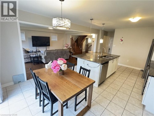 Kitchen featuring an island with stone countertop, double sink, and pendant lighting - 67 Pointer Street, Cambridge, ON 