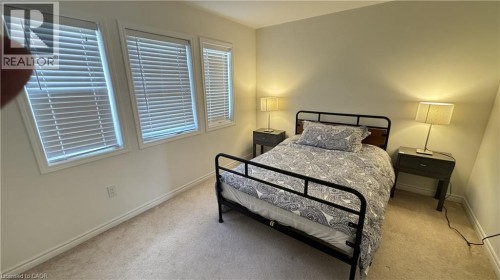 Three windows with horizontal blinds, wall-to-wall carpeting, and neutral paint - 67 Pointer Street, Cambridge, ON 