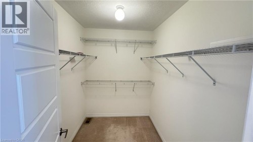 Carpeted closet with ample wire shelving and a contemporary flush-mount light fixture - 67 Pointer Street, Cambridge, ON 