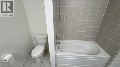 Tiled tub and shower combination with a white porcelain toilet - 67 Pointer Street, Cambridge, ON 