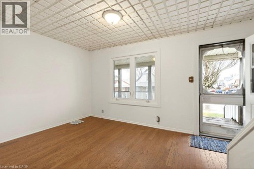 Hardwood-finish flooring, white walls, and a multi-pane window - 23 Frederick Avenue, Hamilton, ON 
