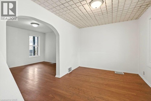 Wood-finish flooring throughout, complemented by white walls - 23 Frederick Avenue, Hamilton, ON 
