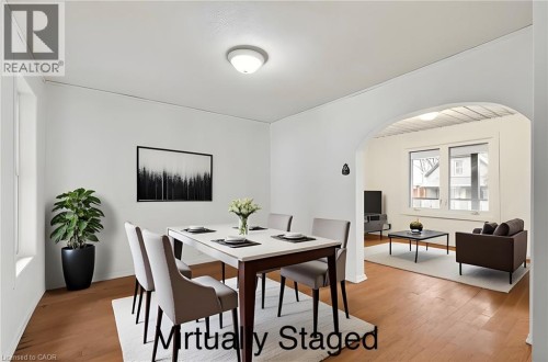 Hardwood-style flooring throughout, arched doorway, recessed lighting, and large window - 23 Frederick Avenue, Hamilton, ON 