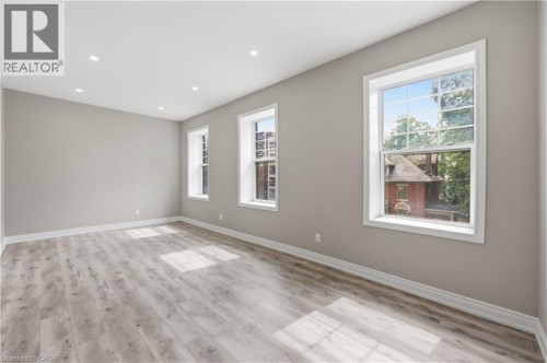 Spacious room featuring wood-finish flooring, recessed lighting, and multiple windows with white trim - 98 Duke Street Unit# 2Nd, Hamilton, ON 