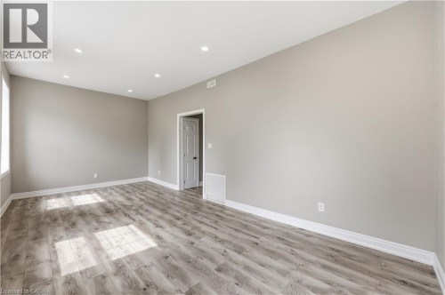 Recessed lighting, wood-finish flooring, light gray wall paint, white trim, and a white interior door - 98 Duke Street Unit# 2Nd, Hamilton, ON 