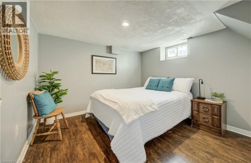 Wood-finish flooring with light gray walls, an egress window, and recessed ceiling lighting - 176 Edwin Street, Kitchener, ON 