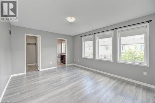Spacious room featuring light wood-finish flooring, light gray wall paint, and white trim - 103 Blackbird Circle, Cambridge, ON 