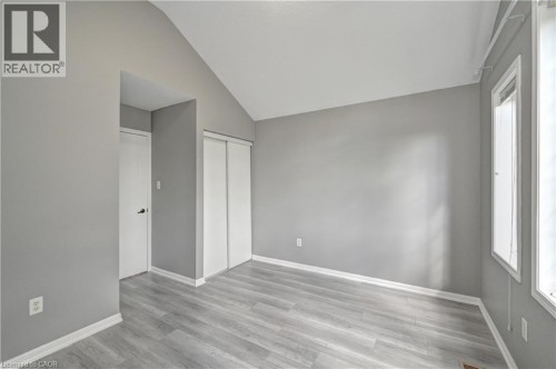 Vaulted ceiling, light wood-finish flooring, white trim, sliding closet doors, and multiple windows - 103 Blackbird Circle, Cambridge, ON 