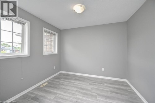 Light gray walls complemented by wood-finish flooring - 103 Blackbird Circle, Cambridge, ON 