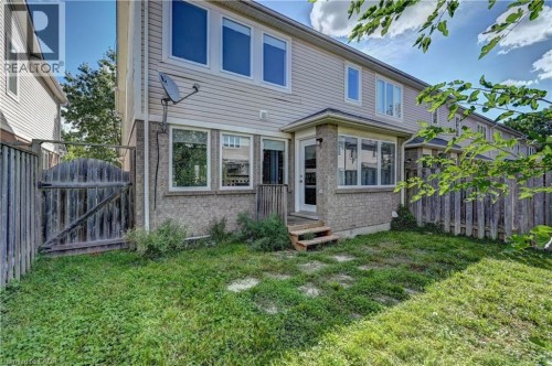 Rear exterior featuring a bay window, a rear entry door, and stone and siding facade - 103 Blackbird Circle, Cambridge, ON 