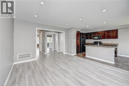 Open concept living area featuring wood-finish flooring and recessed lighting - 103 Blackbird Circle, Cambridge, ON 