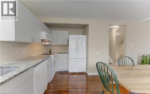 White cabinetry, granite-finish countertops, White appliances, and wood-finish flooring - 104 Mausser Avenue, Kitchener, ON 