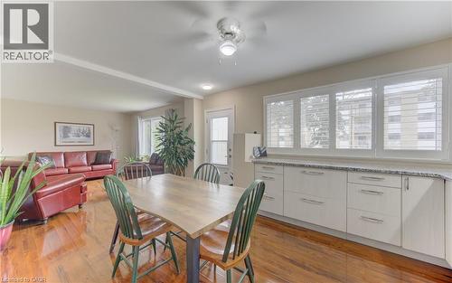 Open-concept living area featuring wood-finish flooring, a ceiling fan with integrated lighting, and extensive cabinetry with a light-toned countertop - 104 Mausser Avenue, Kitchener, ON 