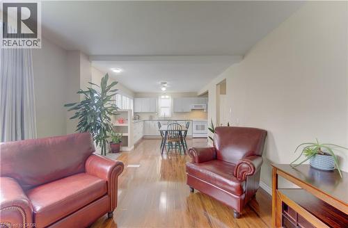 Hardwood-finish flooring, recessed lighting, and a white kitchen with white cabinetry - 104 Mausser Avenue, Kitchener, ON 