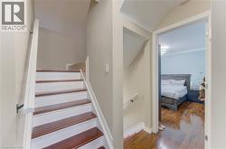 Staircase with wood-finish treads and white risers, featuring a white handrail - 