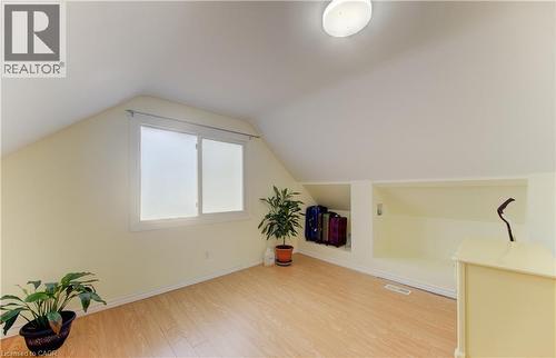 Sloped ceilings, wood-finish flooring, a double window, built-in recessed shelving, and a flush-mount ceiling light - 104 Mausser Avenue, Kitchener, ON 
