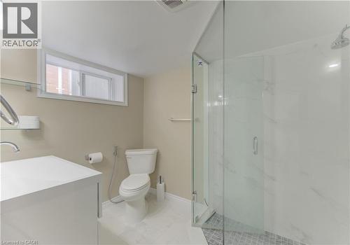 Glass-enclosed shower with tiled flooring, white vanity, and ceramic toilet - 104 Mausser Avenue, Kitchener, ON 