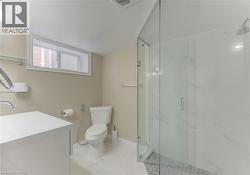 Glass-enclosed shower with tiled flooring, white vanity, and ceramic toilet - 