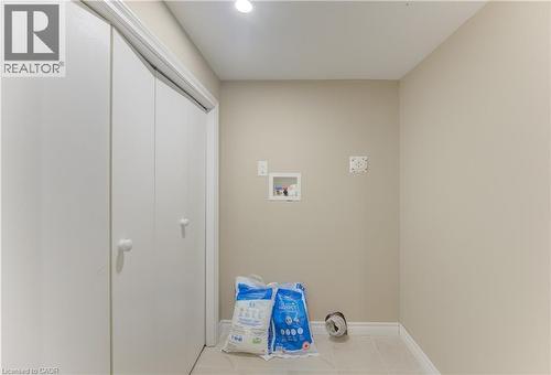 Laundry area with light-toned walls, tile flooring, and integrated utility connections - 104 Mausser Avenue, Kitchener, ON 