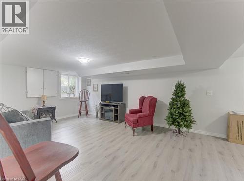 Spacious room with light-toned wood-finish flooring, white walls, and a dropped ceiling feature - 104 Mausser Avenue, Kitchener, ON 